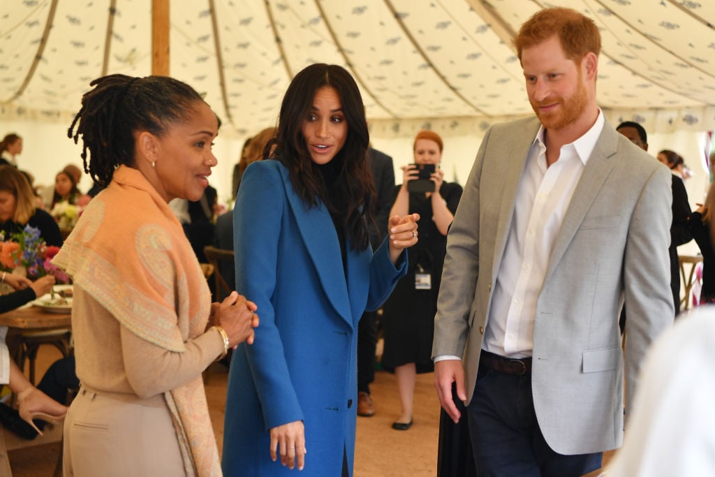 Meghan, Duchess of Sussex (C) arrives with her mother Doria Ragland (L) and Prince Harry, Duke of Sussex to host an event to mark the launch of a cookbook with recipes from a group of women affected by the Grenfell Tower fire at Kensington Palace on September 20, 2018 in London, England