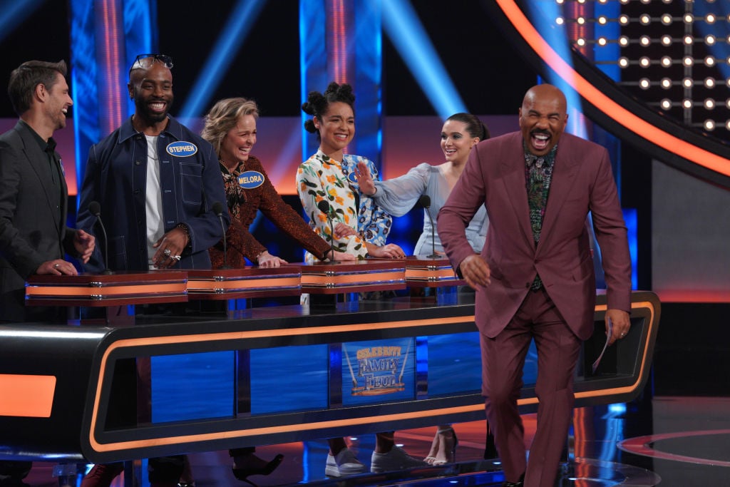 Steve Harvey laughing on stage with cast members of 'The Bold Type' on 'Celebrity Family Feud'