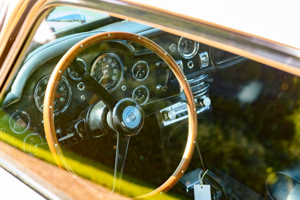 Aston Martin steering wheel photographed through the driver side window