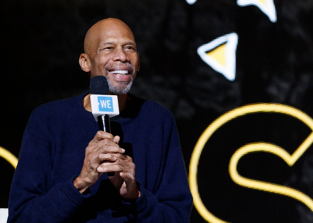 Kareem Abdul-Jabbar smiling holding a microphone