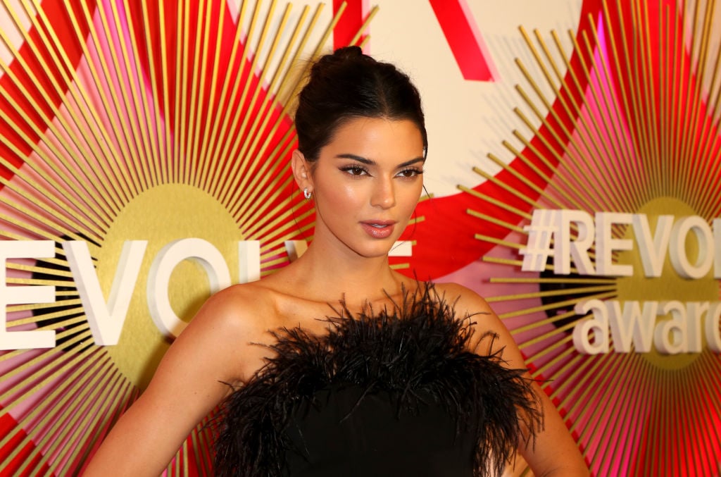 Kendall Jenner in front of a red and pink background
