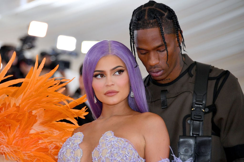 Kylie Jenner looking past the camera slightly in front of Travis Scott, who is looking down