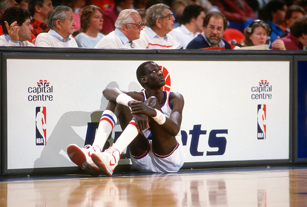 Manute Bol waiting to go into an NBA game