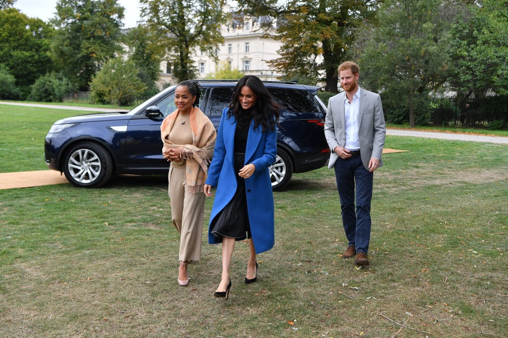 Meghan, Duchess of Sussex (C) arrives with her mother Doria Ragland (L) and Prince Harry, Duke of Sussex to host an event to mark the launch of a cookbook with recipes from a group of women affected by the Grenfell Tower fire at Kensington Palace on September 20, 2018 in London, England