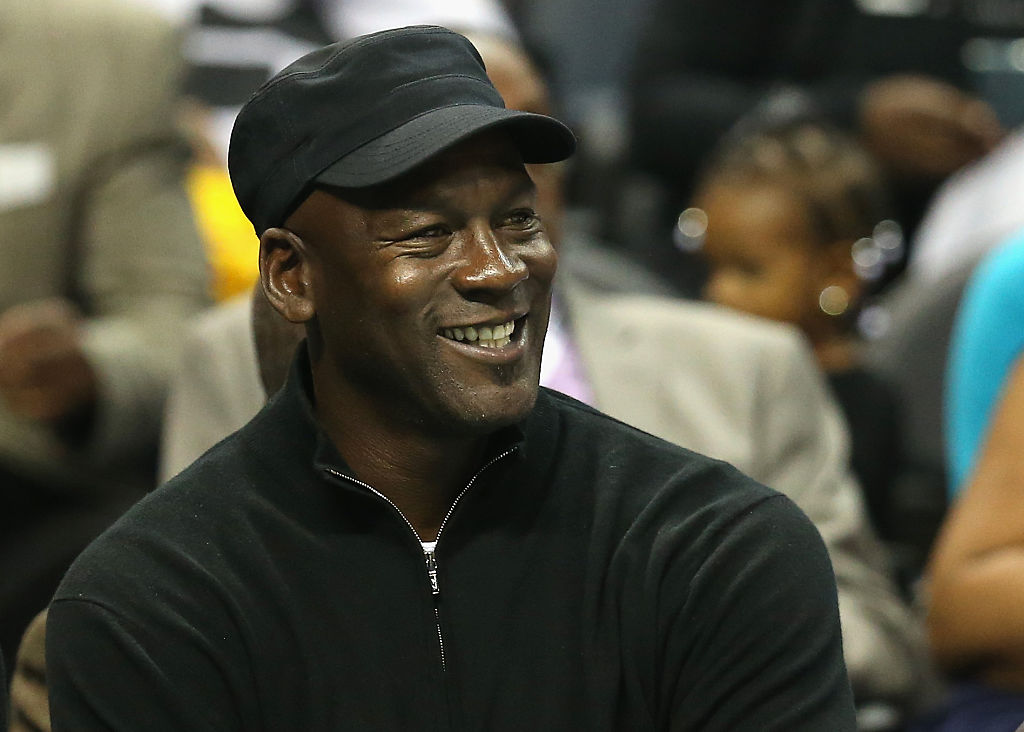 Michael Jordan wearing a black hat smiling