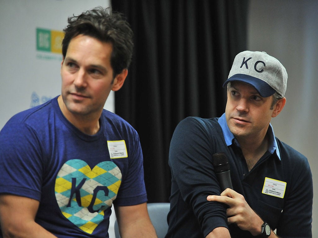 Paul Rudd and Jason Sudeikis smiling, holding microphones