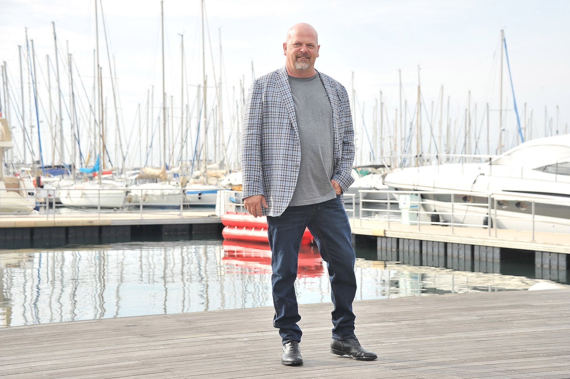 Rick Harrison smiling, standing on a dock in front of a marina
