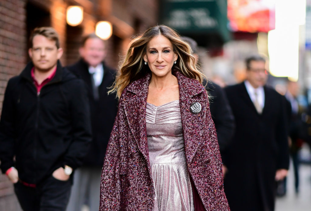 Sarah Jessica Parker smiling, walking down a NYC street