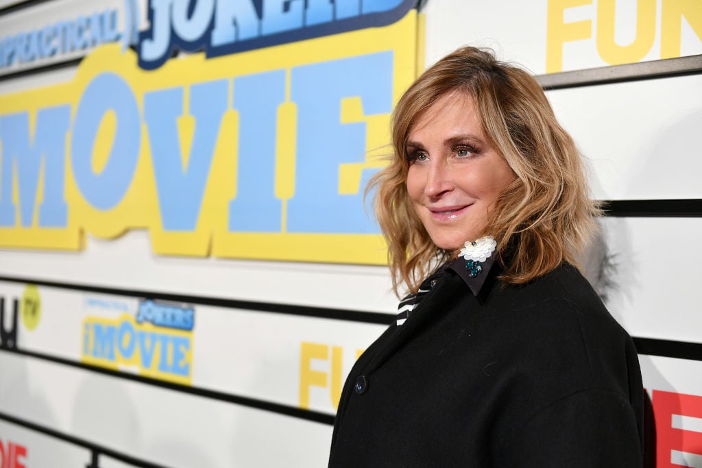 Sonja Morgan smiling in front of a repeating background