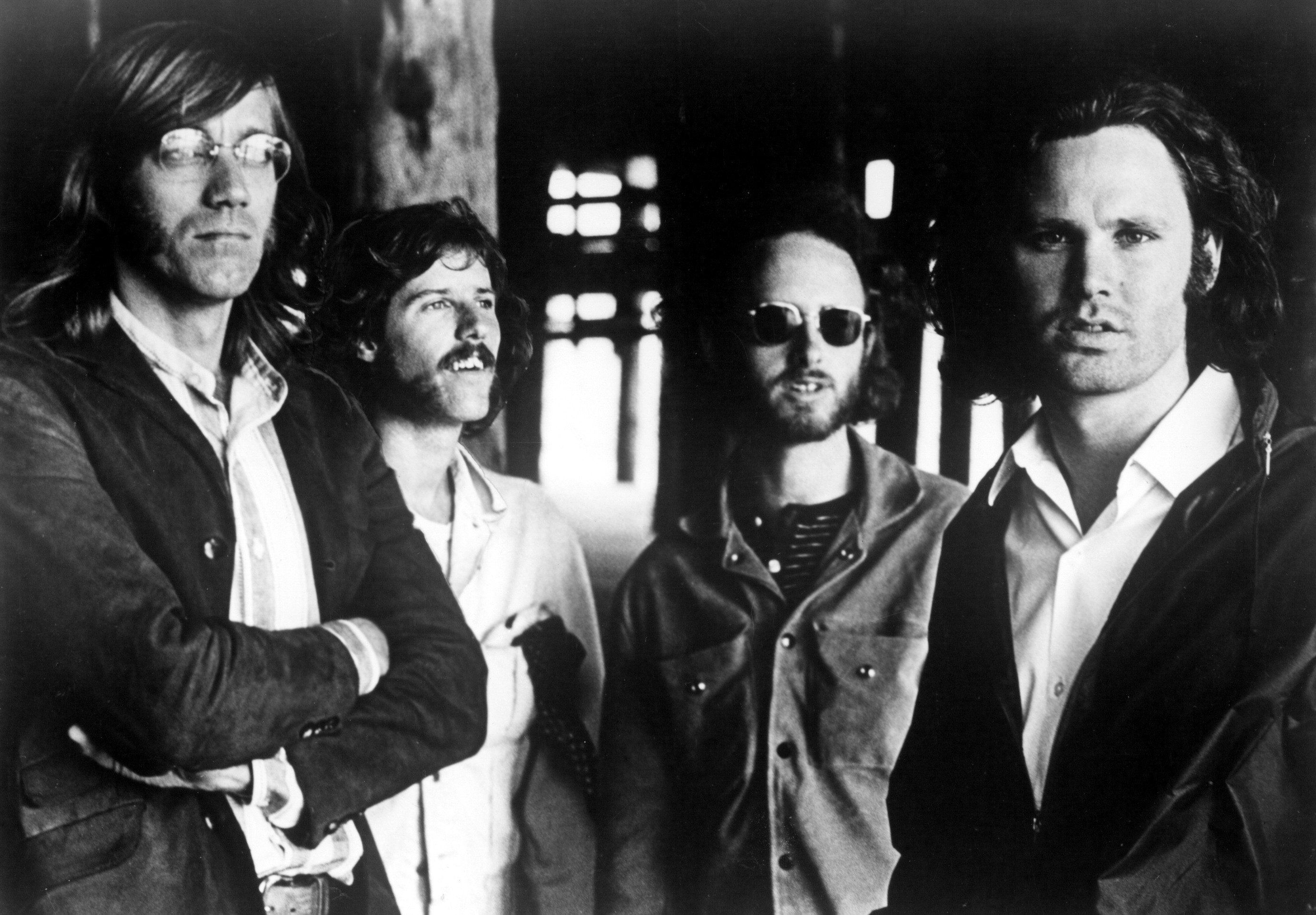 The Doors in black and white, photographed outside some looking at the camera some looking into the distance