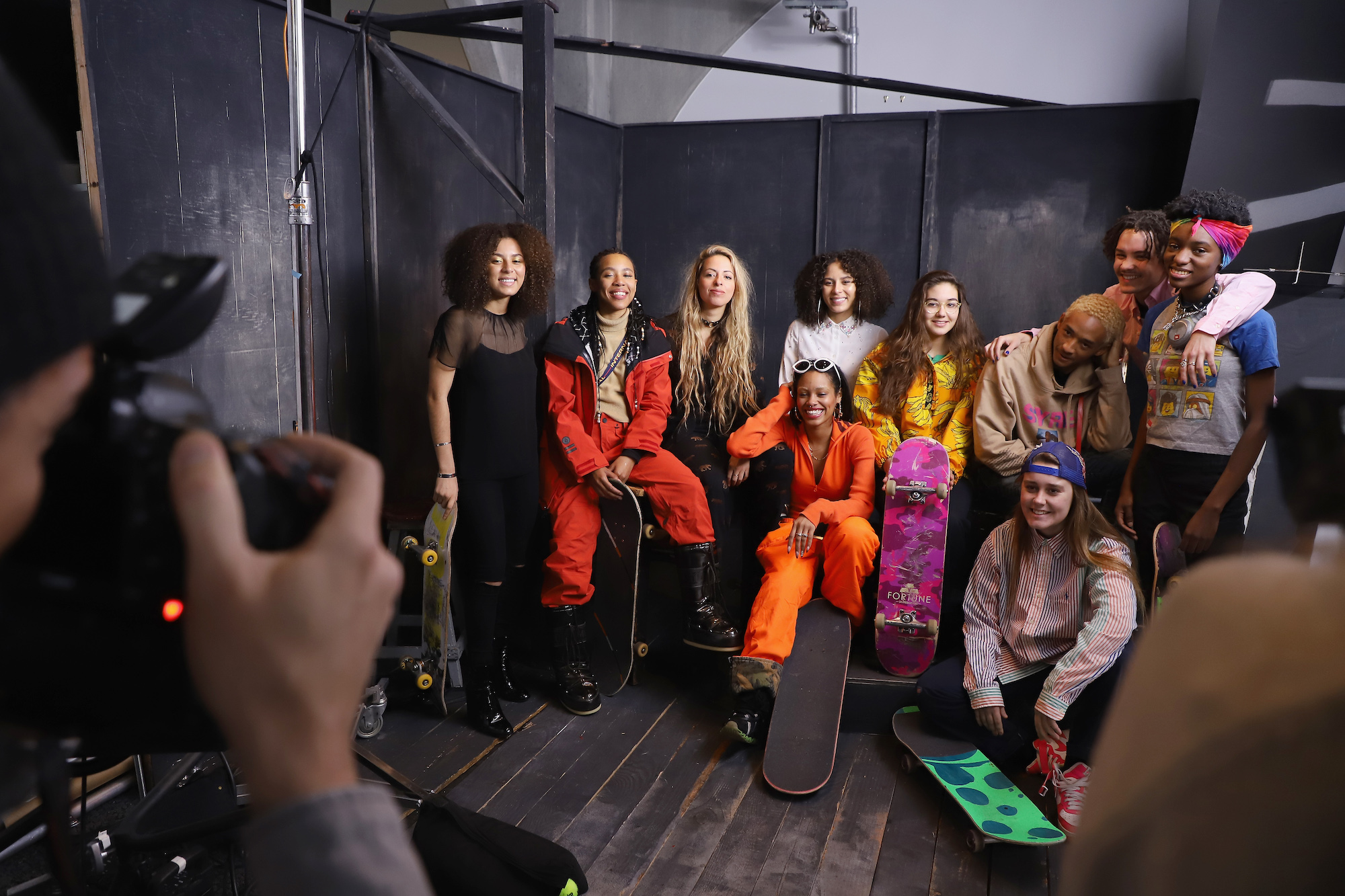 The Skate Kitchen members smiling on a set, holding skateboards