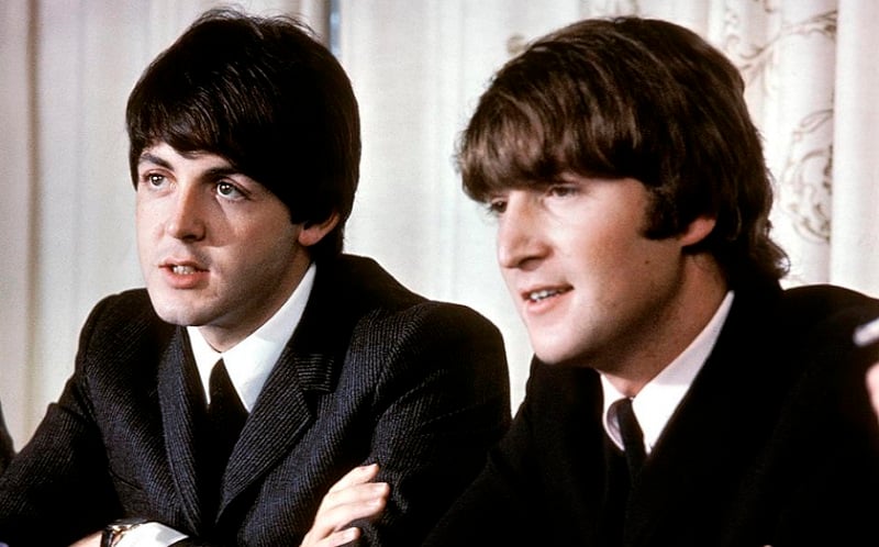 Paul McCartney sitting with John Lennon