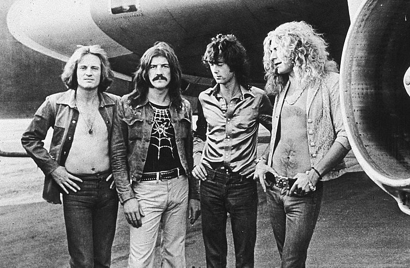Led Zeppelin posed in front of the band airplane
