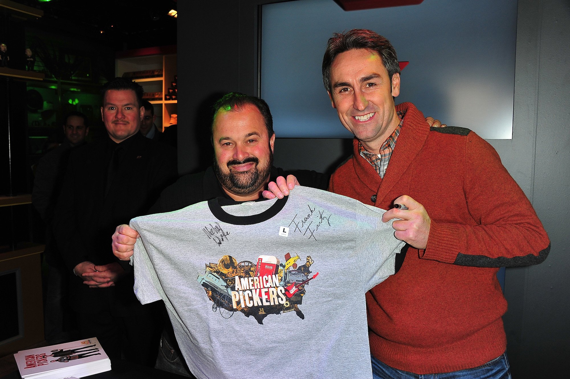 (L-R) Frank Fritz and Mike Wolfe from American Pickers holding up an autographed shirt and smiling