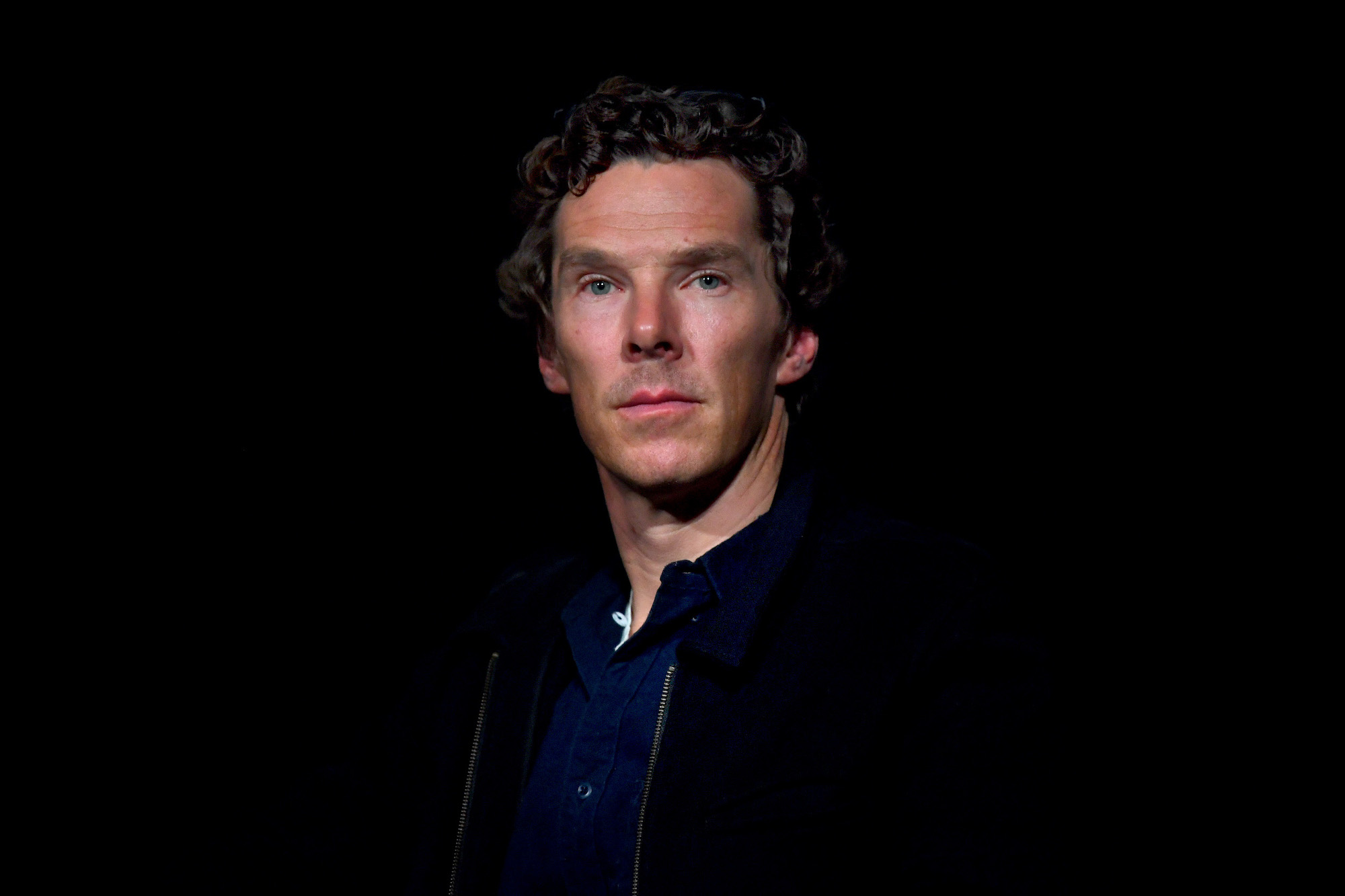 Benedict Cumberbatch looking over the camera, in front of a black background