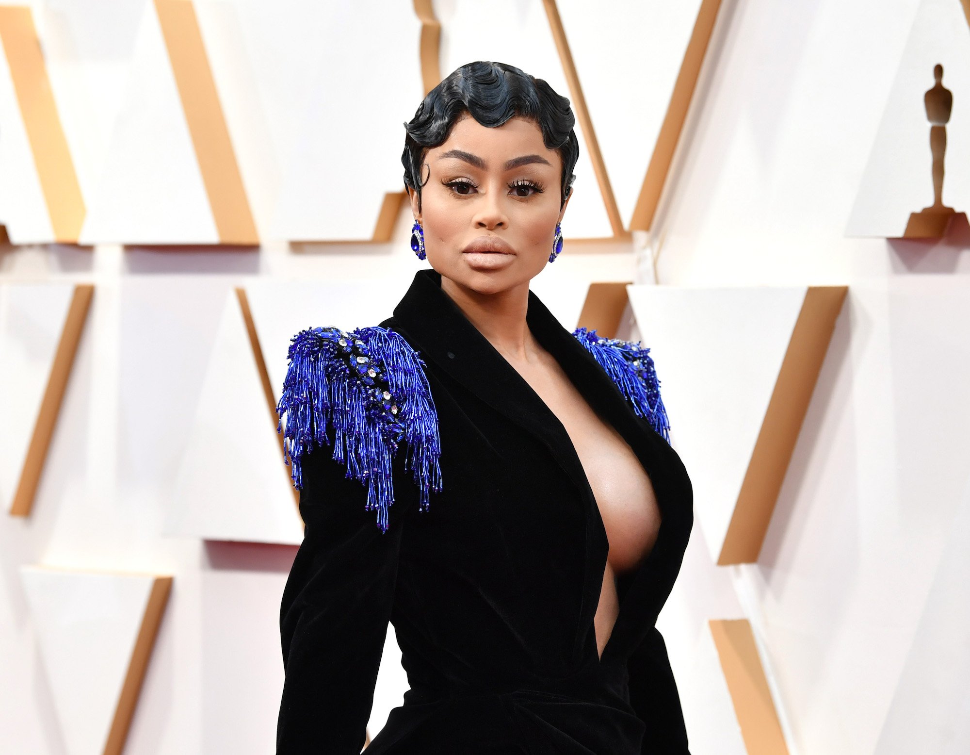 Blac Chyna looking at the camera slightly smiling in front of a geometric backdrop