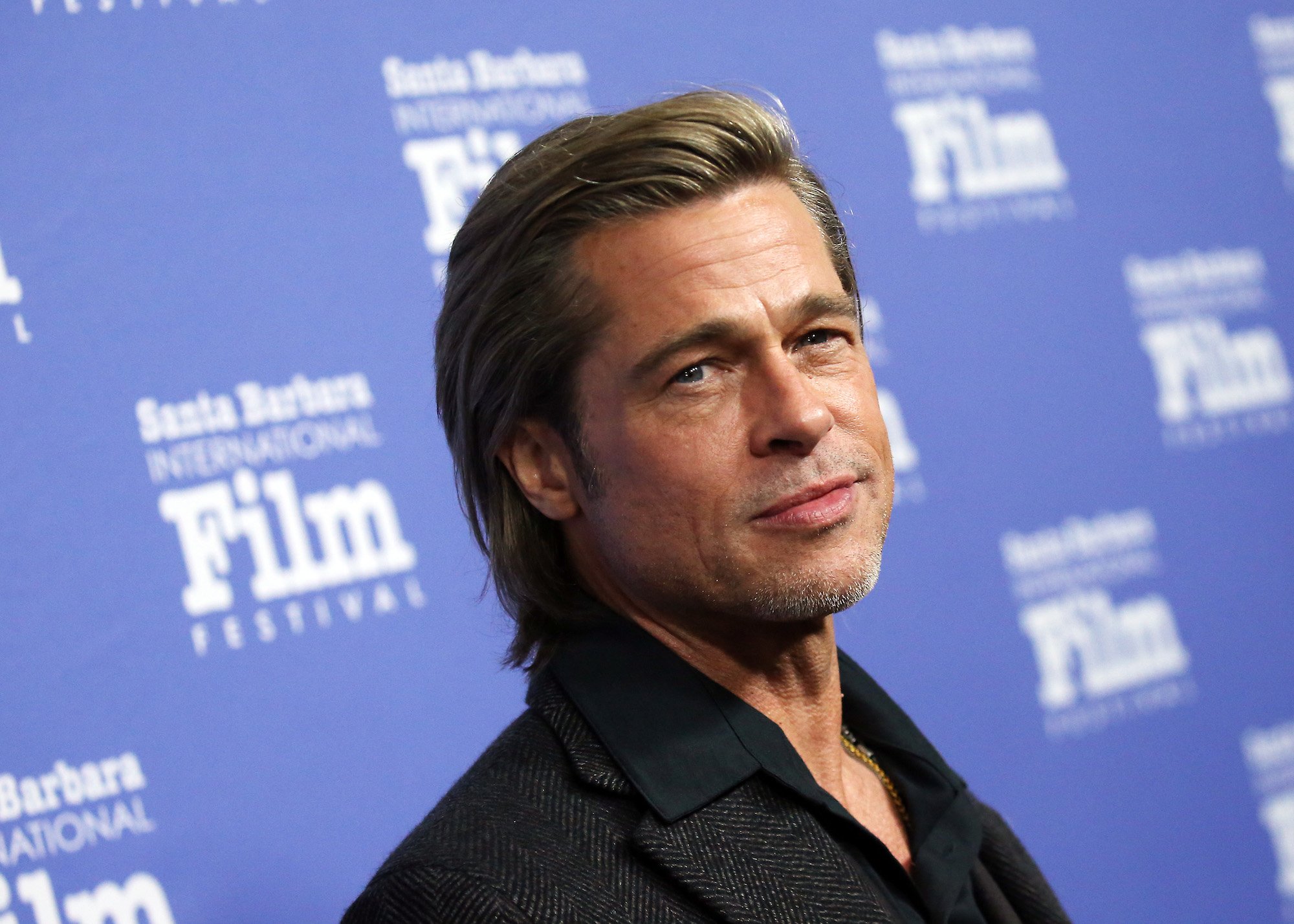 Brad Pitt smiling, turned slightly to the side