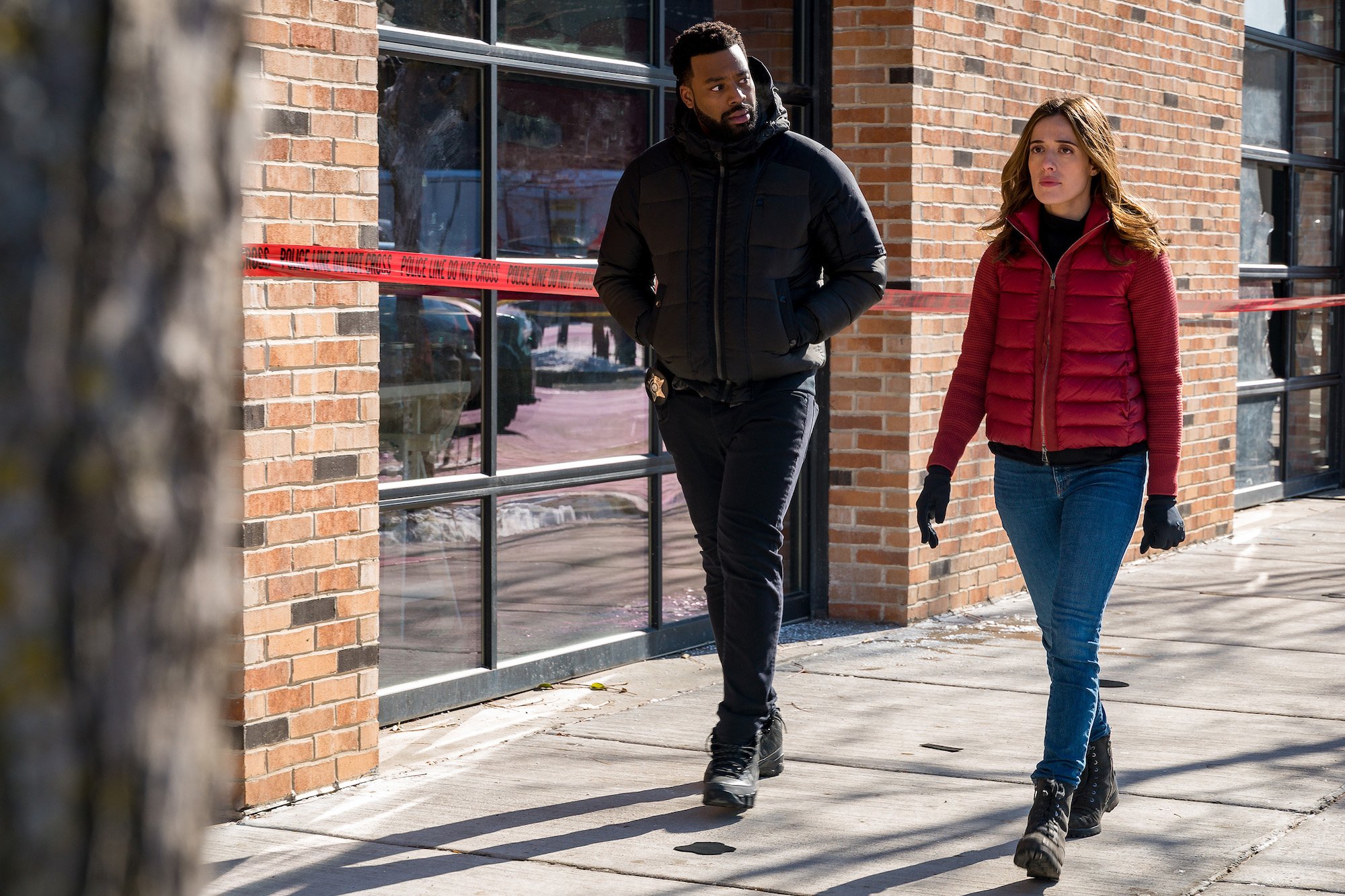 LaRoyce Hawkins as Officer Kevin Atwater, Marina Squerciati as Officer Kim Burgess walking down a street