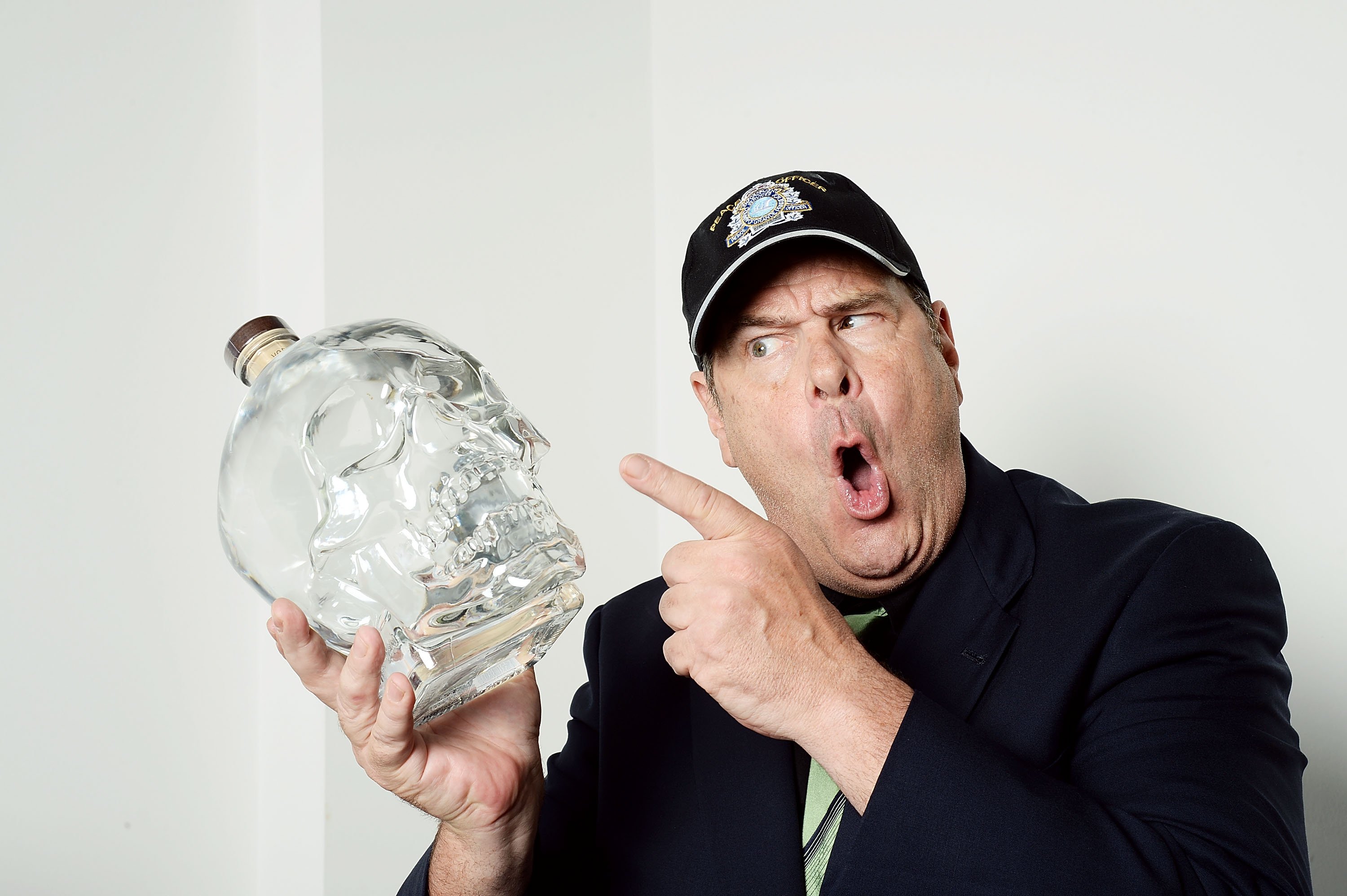 Dan Aykroyd posing with a bottle of vodka