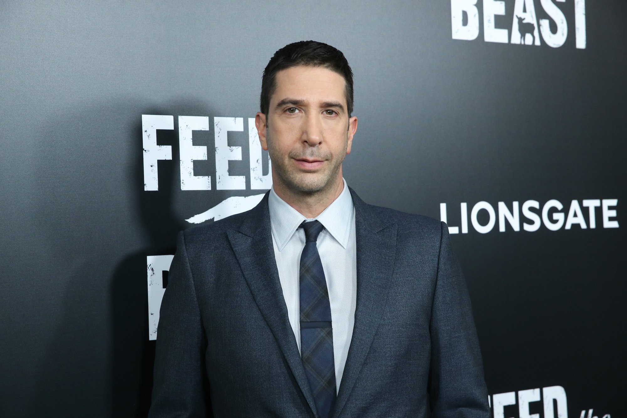 David Schwimmer smiling in front of a black background