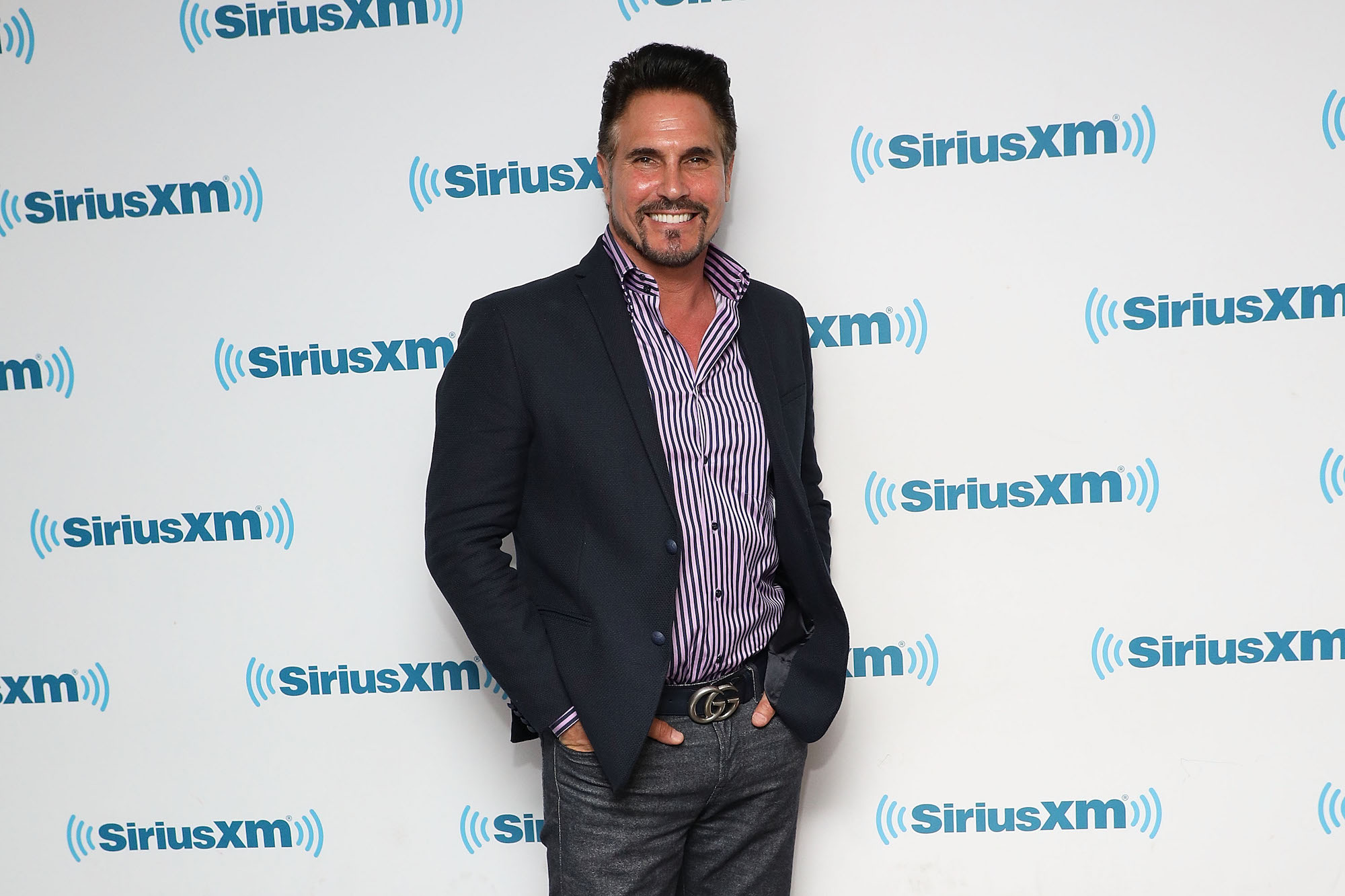 Don Diamont smiling in front of a background with repeating logo