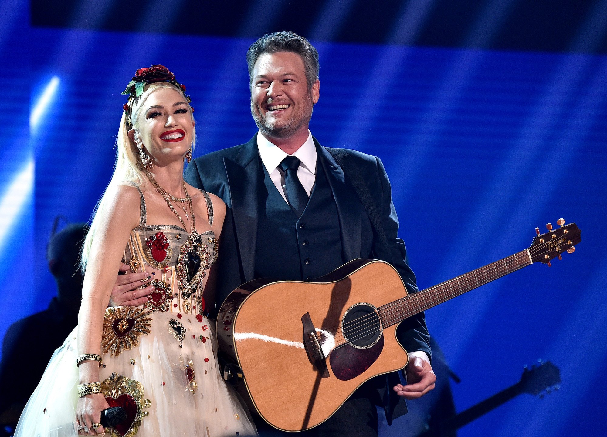 Gwen Stefani and Blake Shelton smiling on stage