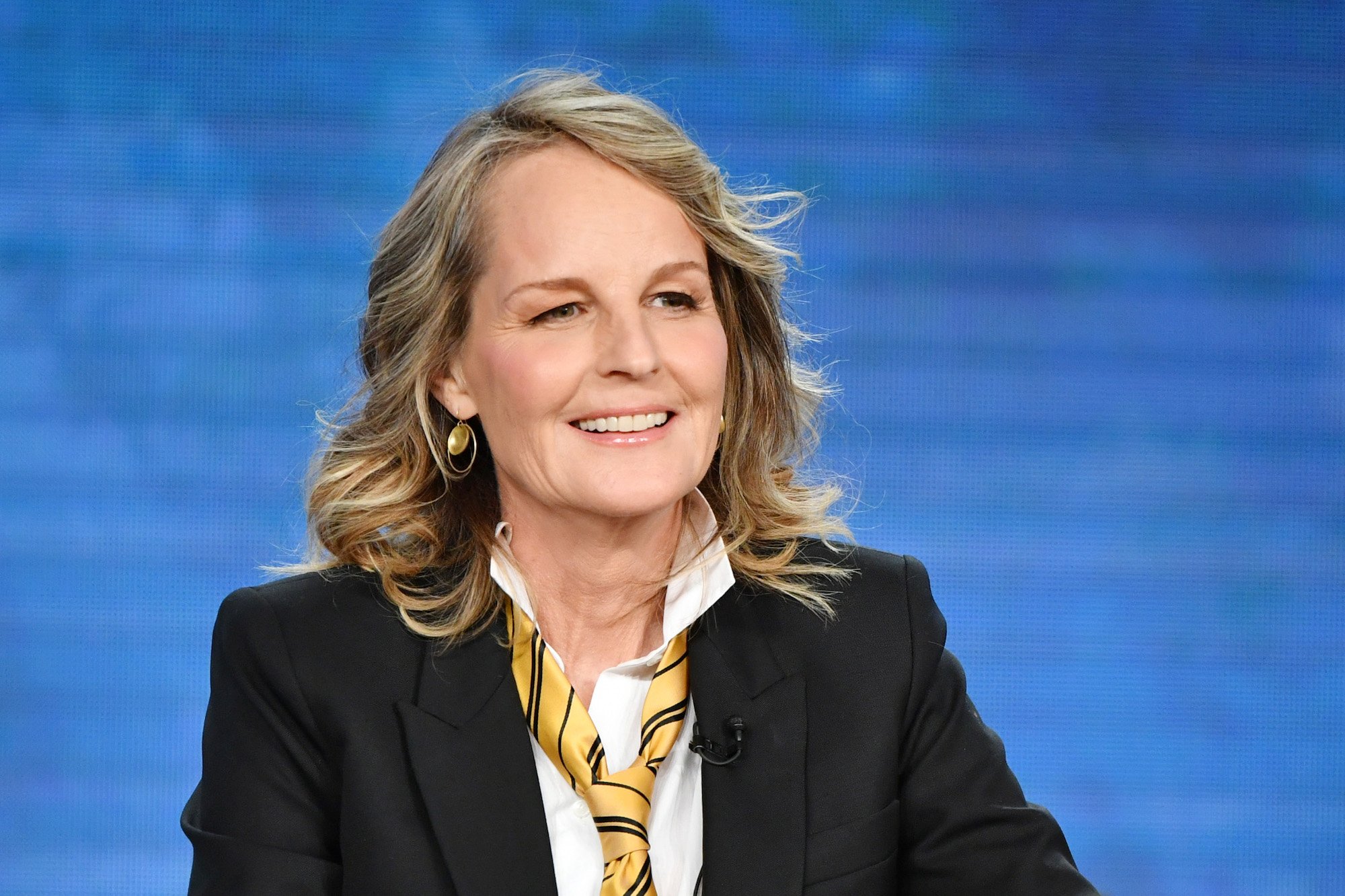 Helen Hunt smiling in front of a blue background