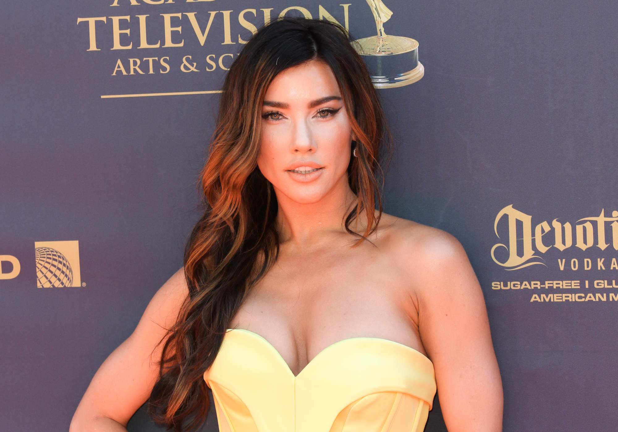 Jacqueline MacInnes Wood looking at the camera in front of a dark blue background