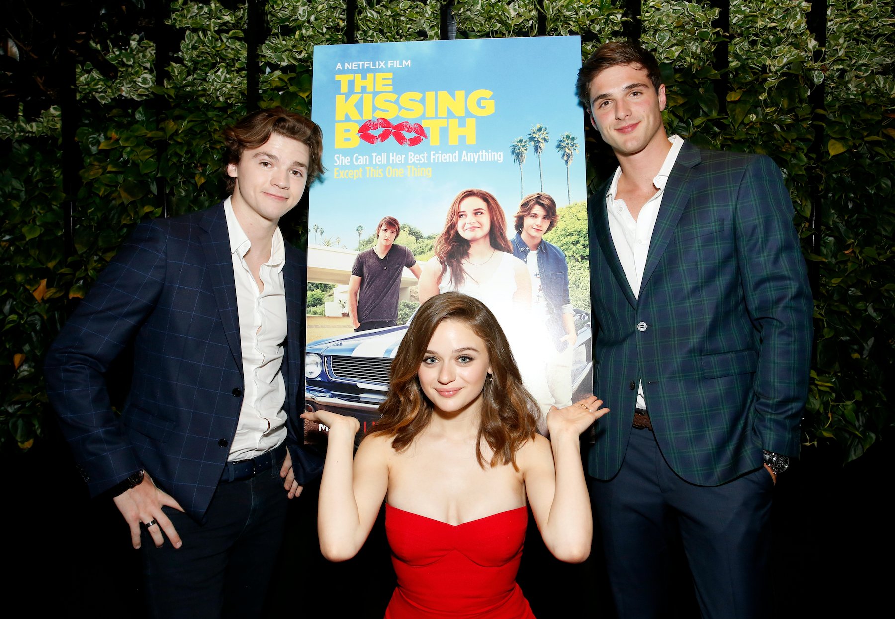 Joel Courtney, Joey King, and Jacob Elordi pose in front of a poster for 'The Kissing Booth'