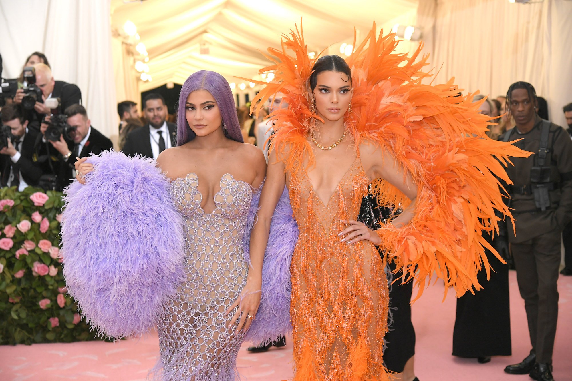 Kylie Jenner and Kendall Jenner looking to the right, wearing purple and orange respectively
