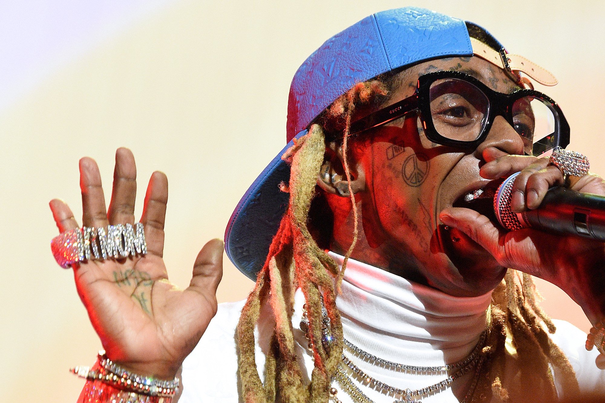 Lil' Wayne holding a microphone to his mouth, performing on stage