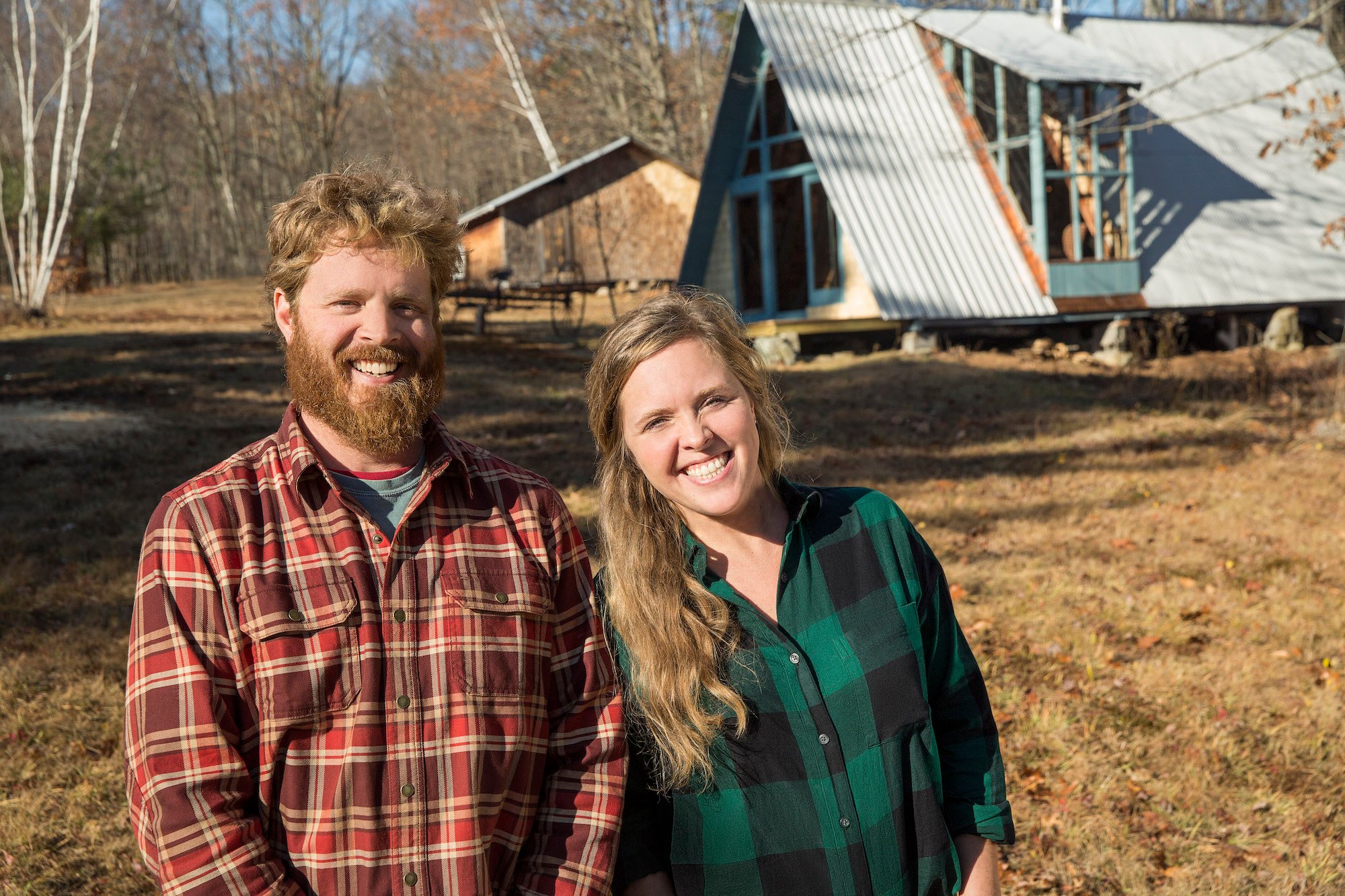 Chase and Ashley Morrill smiling in front of an A-frame house