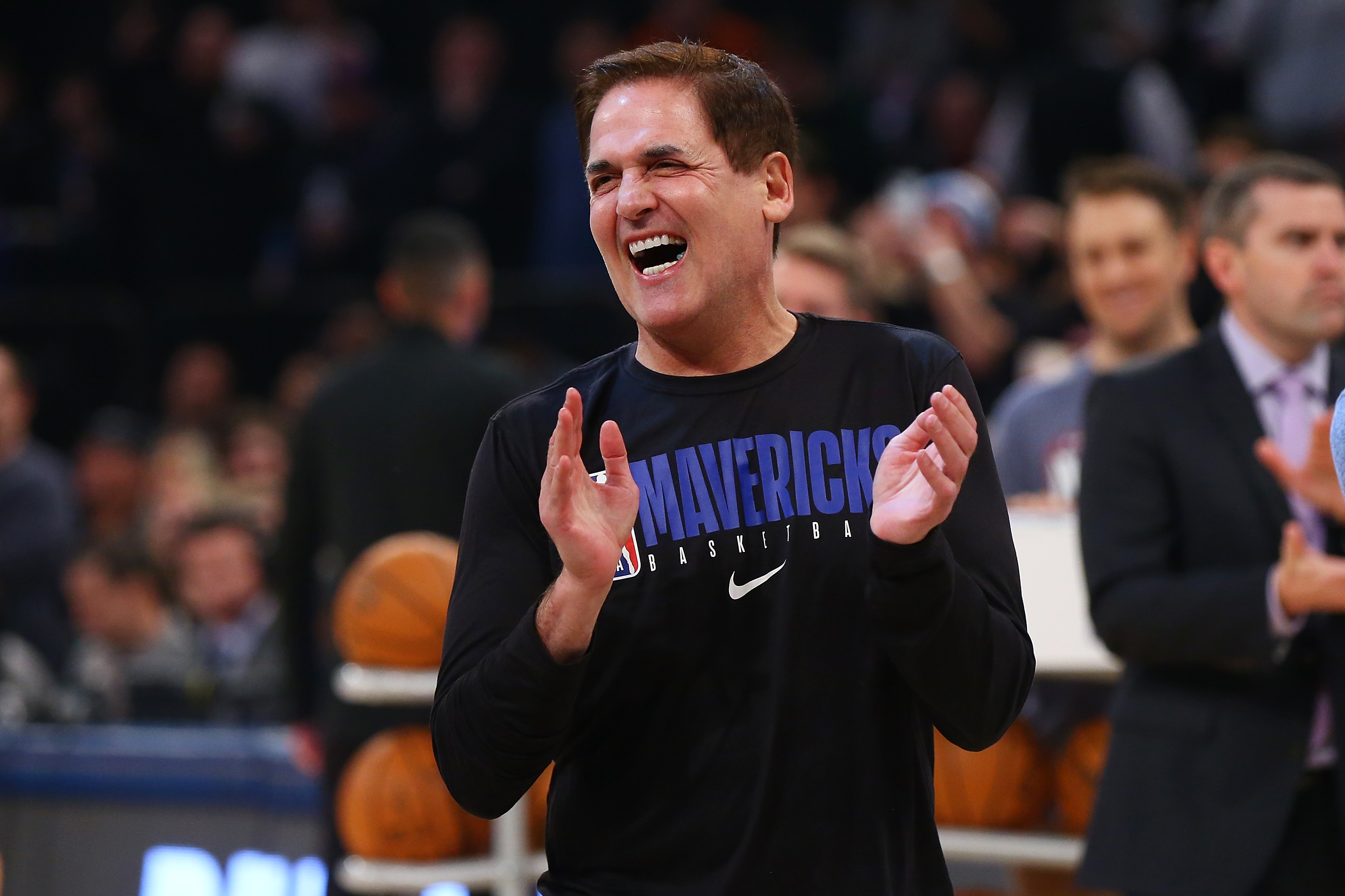 Mark Cuban laughing on the sideline of a Mavericks game