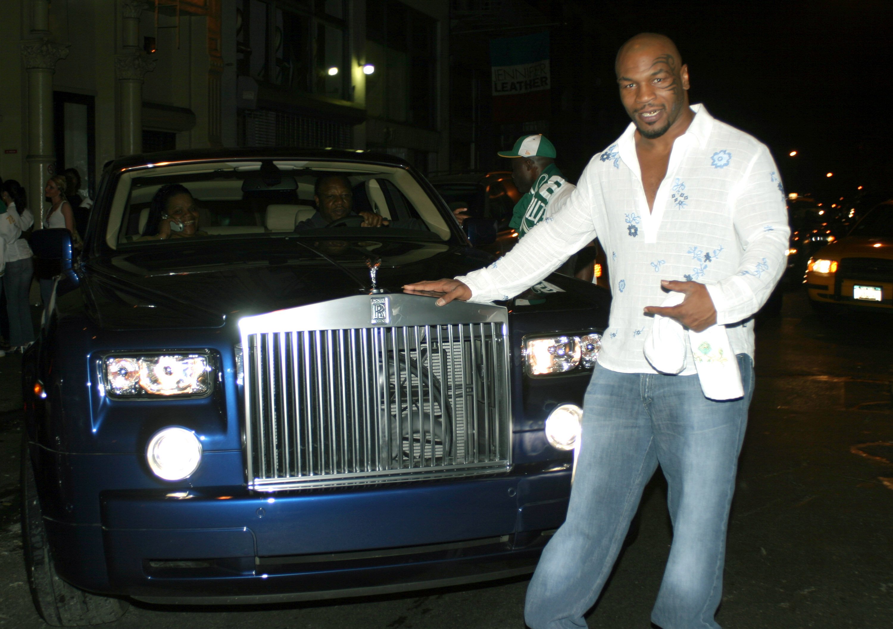 Mike Tyson posing next to a car