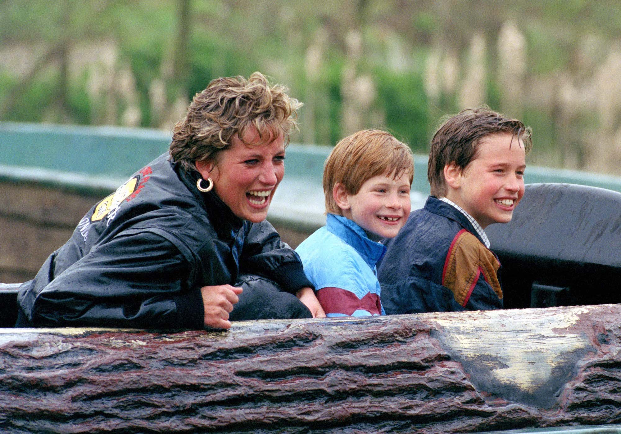 Princess Diana, Prince William, and Prince Harry laughing, wet from rain