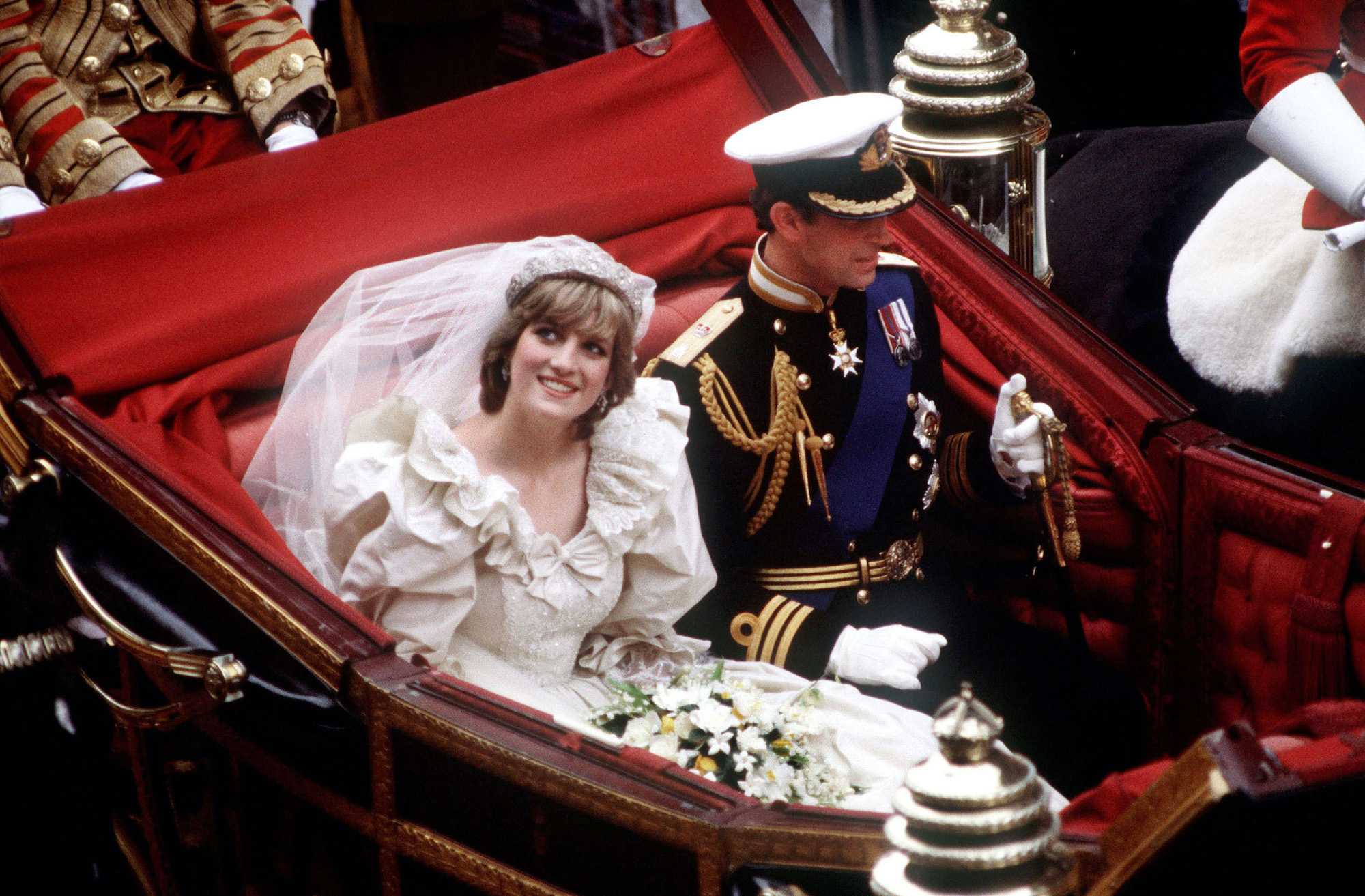 Princess Diana and Prince Charles ride in a carriage back to Buckingham Palace following their 1981 royal wedding