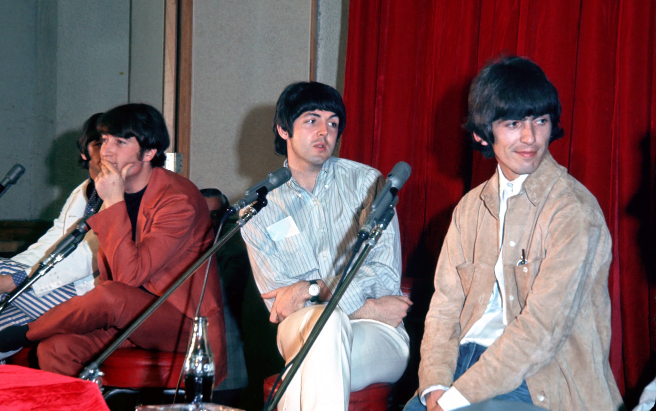 The Beatles seated at a press conference