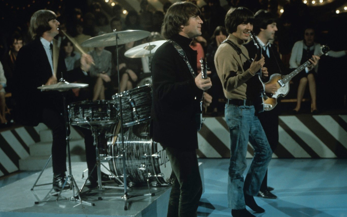 Side view of Beatles performing in 1965