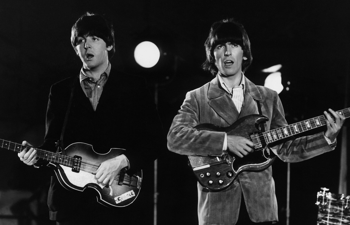 Beatles Paul and George playing their guitars on stage