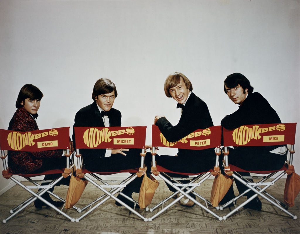 The Monkees sitting in chairs