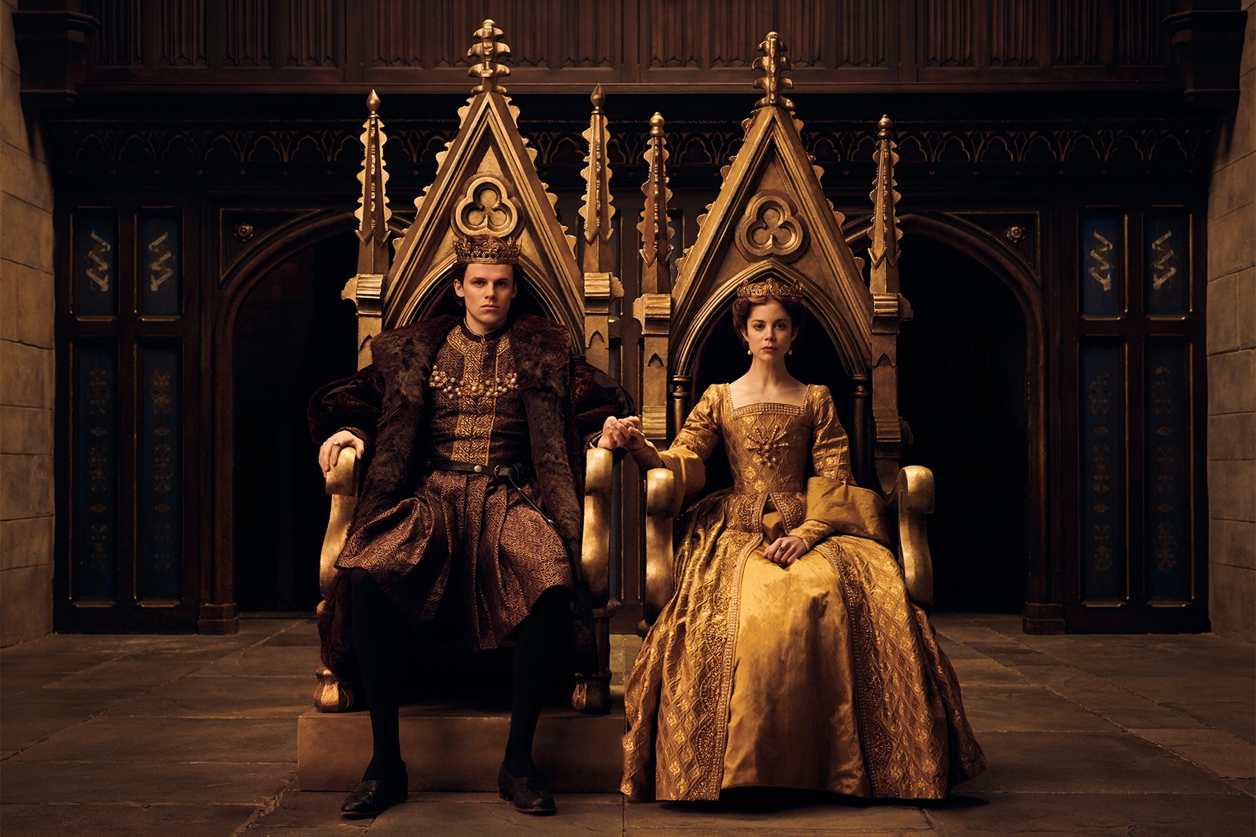 Henry and Catherine sitting on thrones in 'The Spanish Princess' 