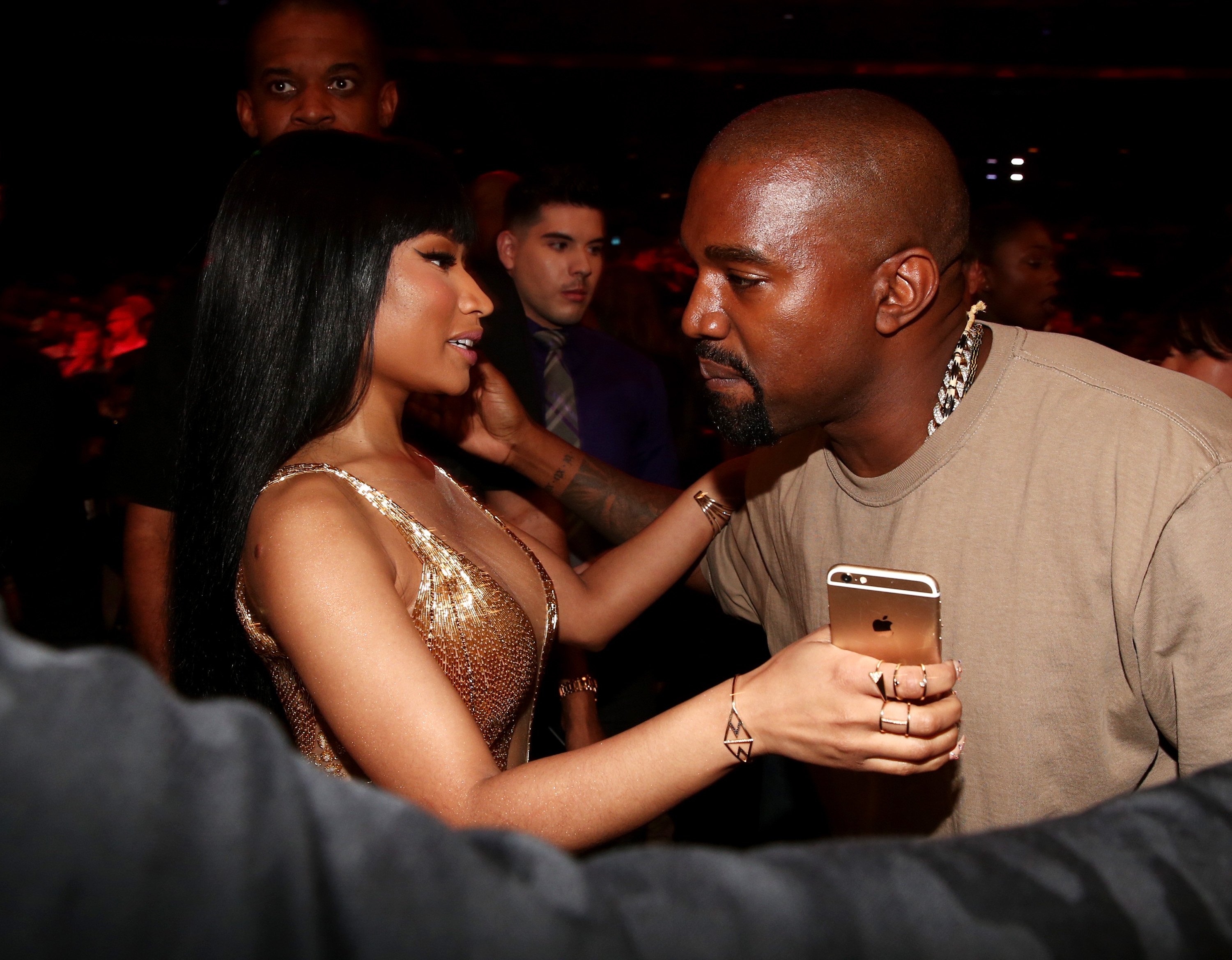 Nicki Minaj putting her arm around Kanye West