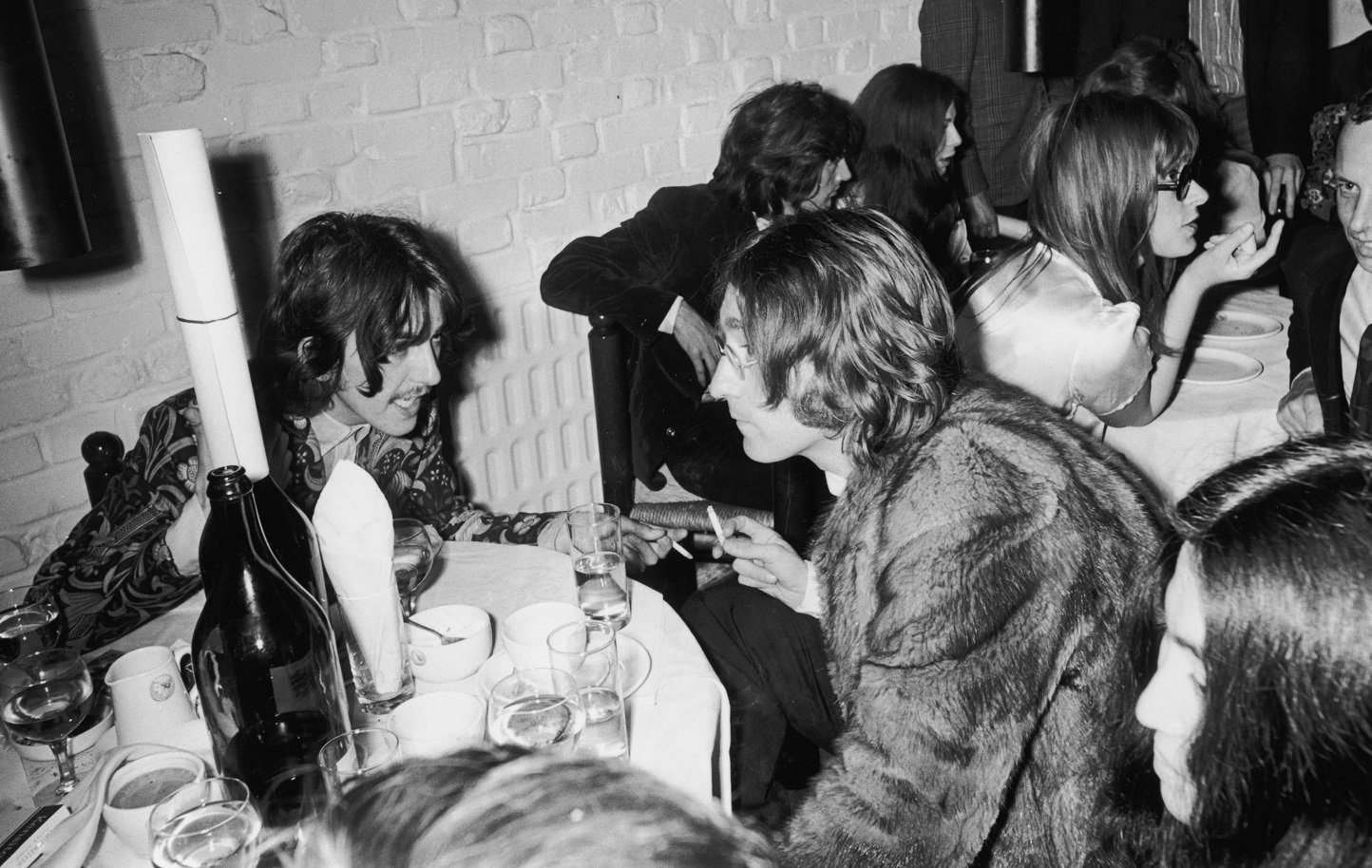 George Harrison and John Lennon speaking as Yoko Ono looks on in 1968