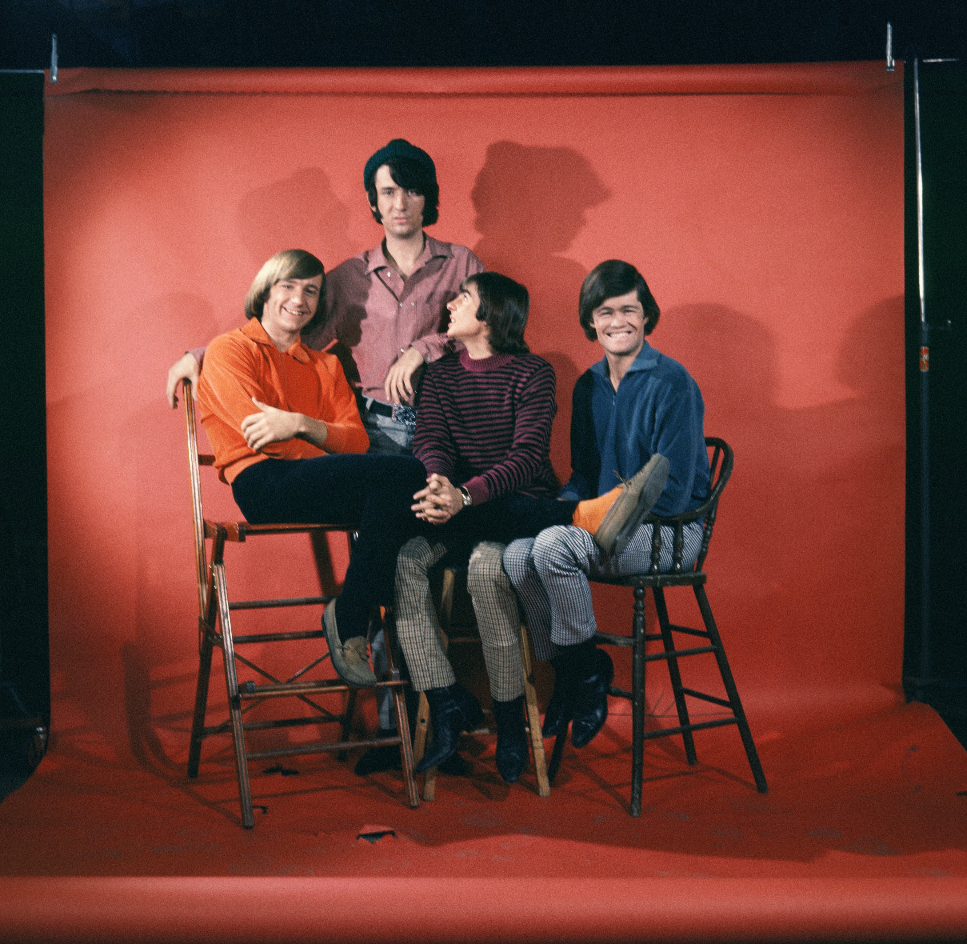 The Monkees in front of a red backdrop