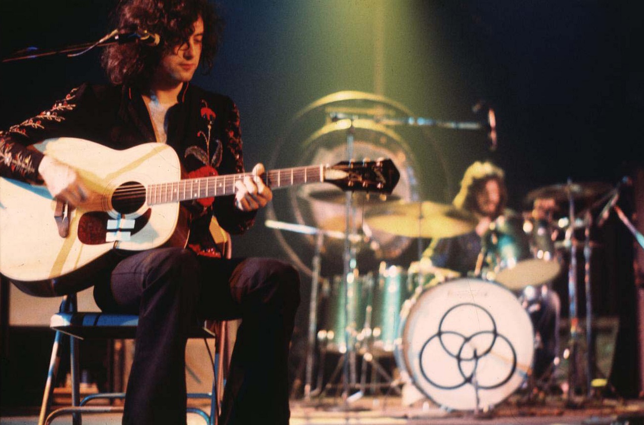 Page seated with guitar and Bonham at the drums on stage
