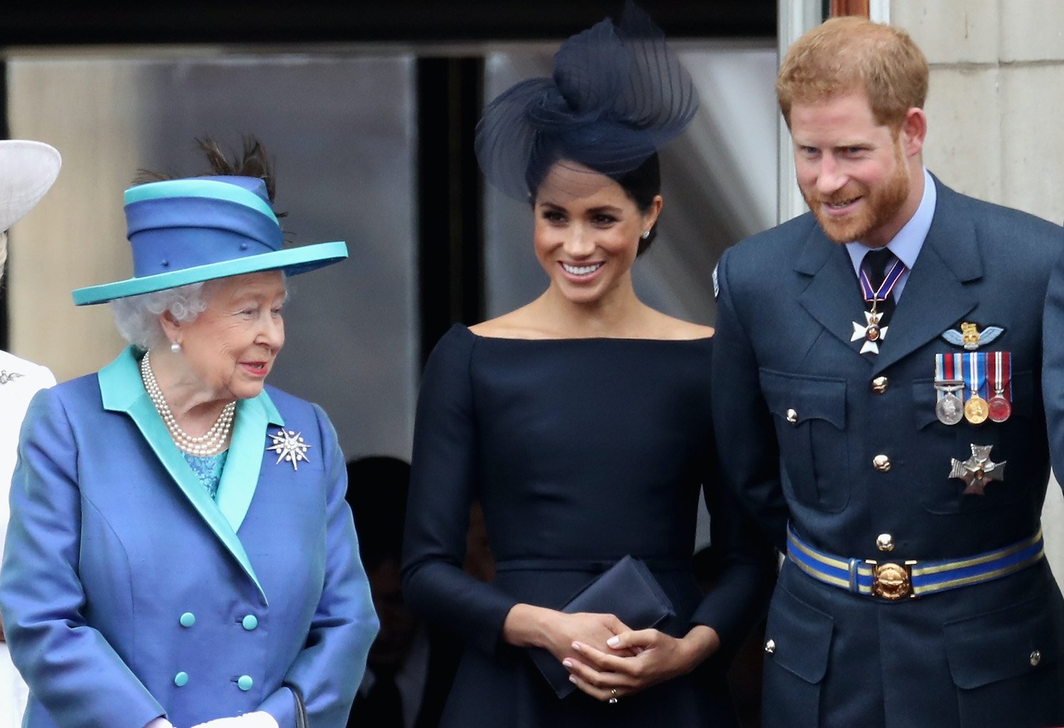 Queen Elizabeth II, Meghan Markle, and Prince Harry watch the RAF flypast on the balcony of Buckingham Palace, as members of the Royal Family attend events to mark the centenary of the RAF