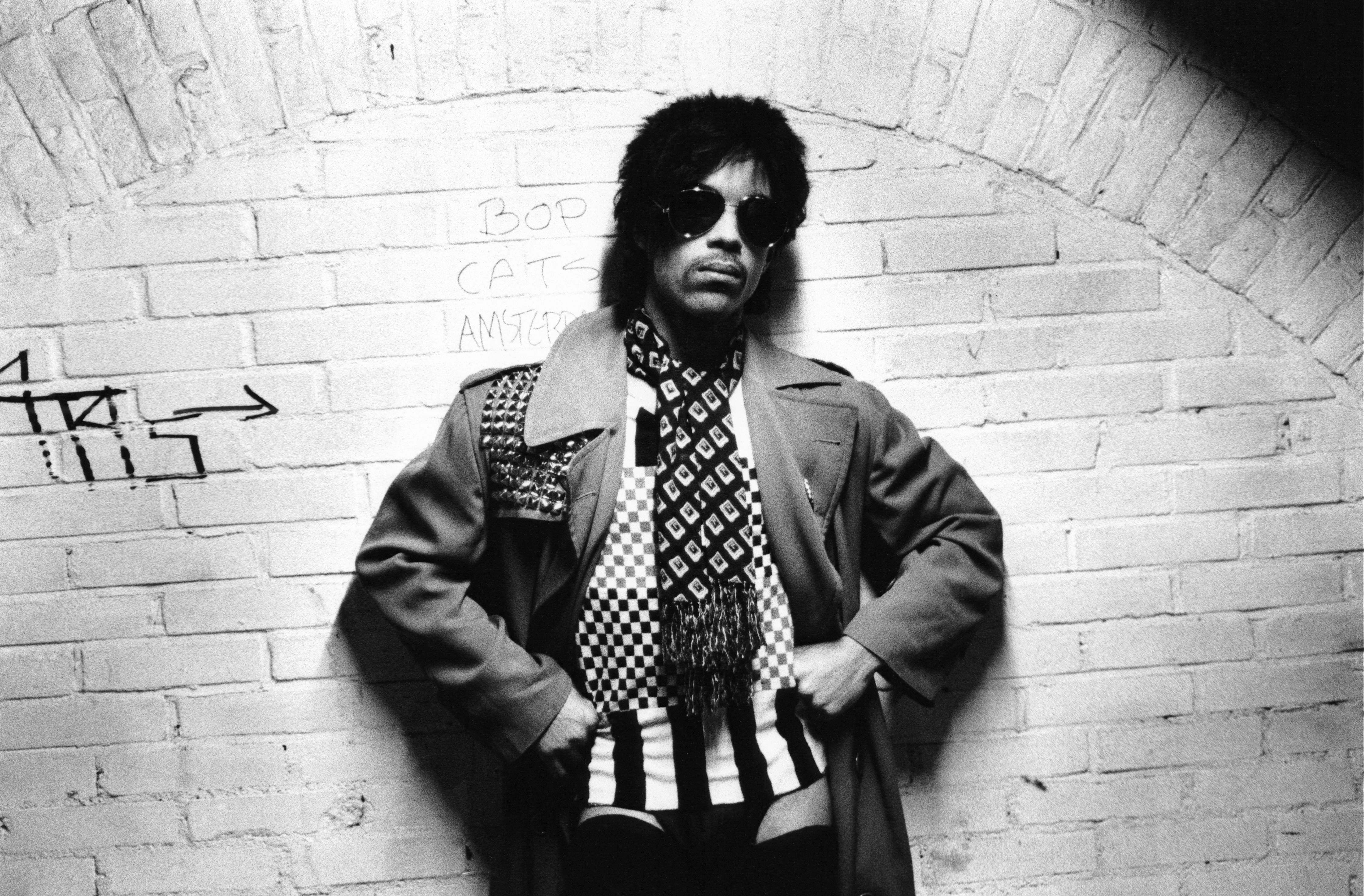 Prince leaning up against a wall