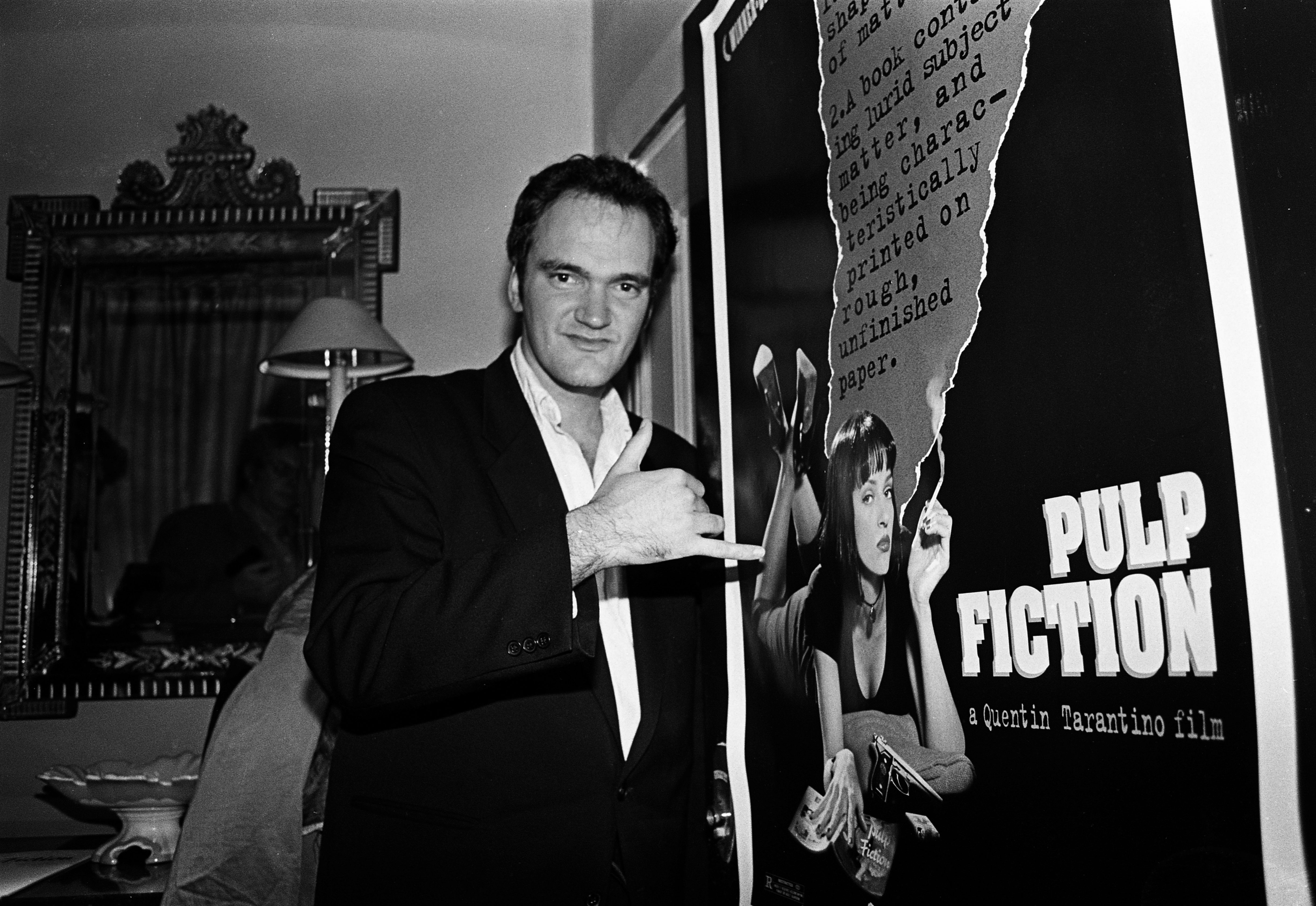 Quentin Tarantino near a Pulp Fiction poster