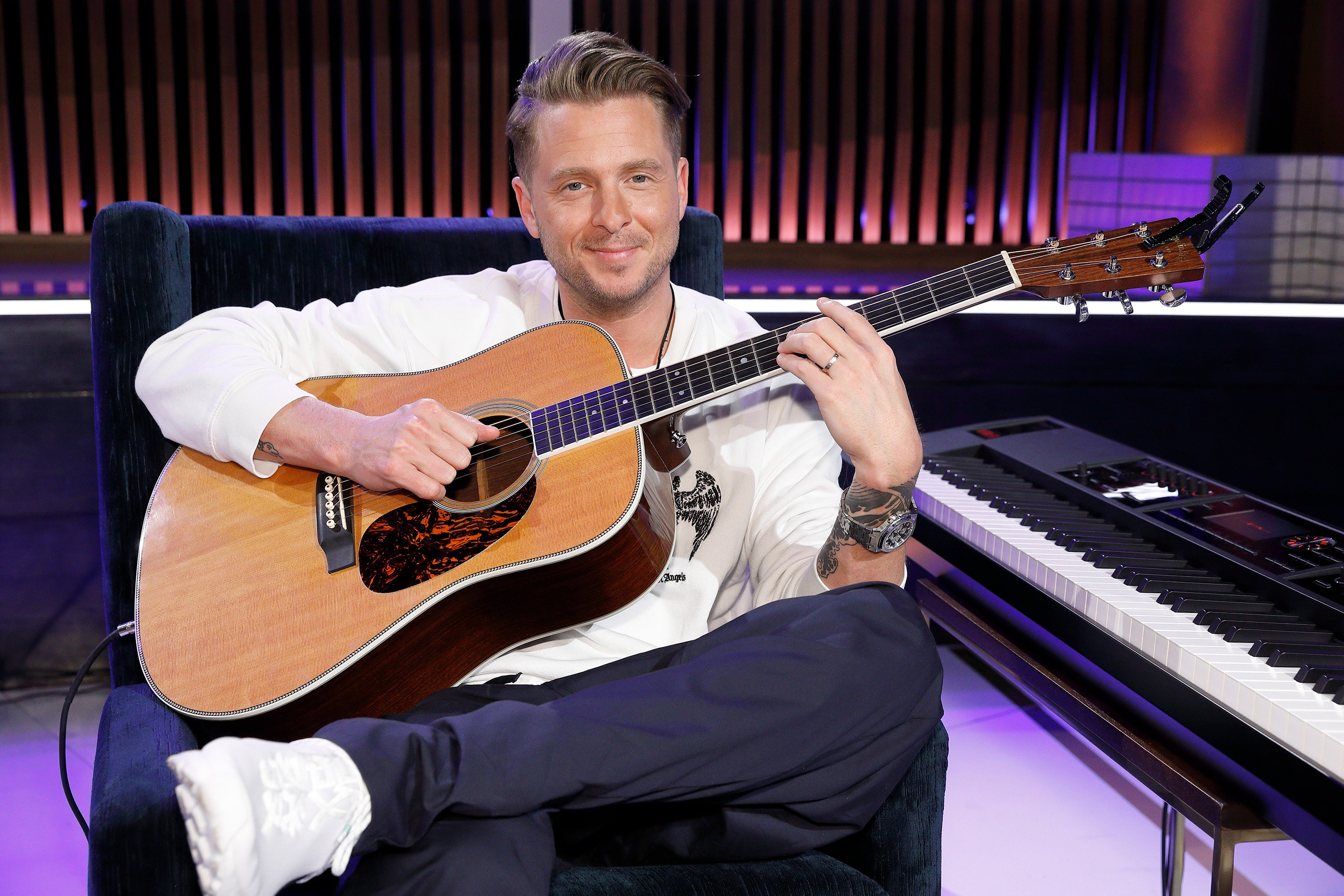 Ryan Tedder holding a guitar