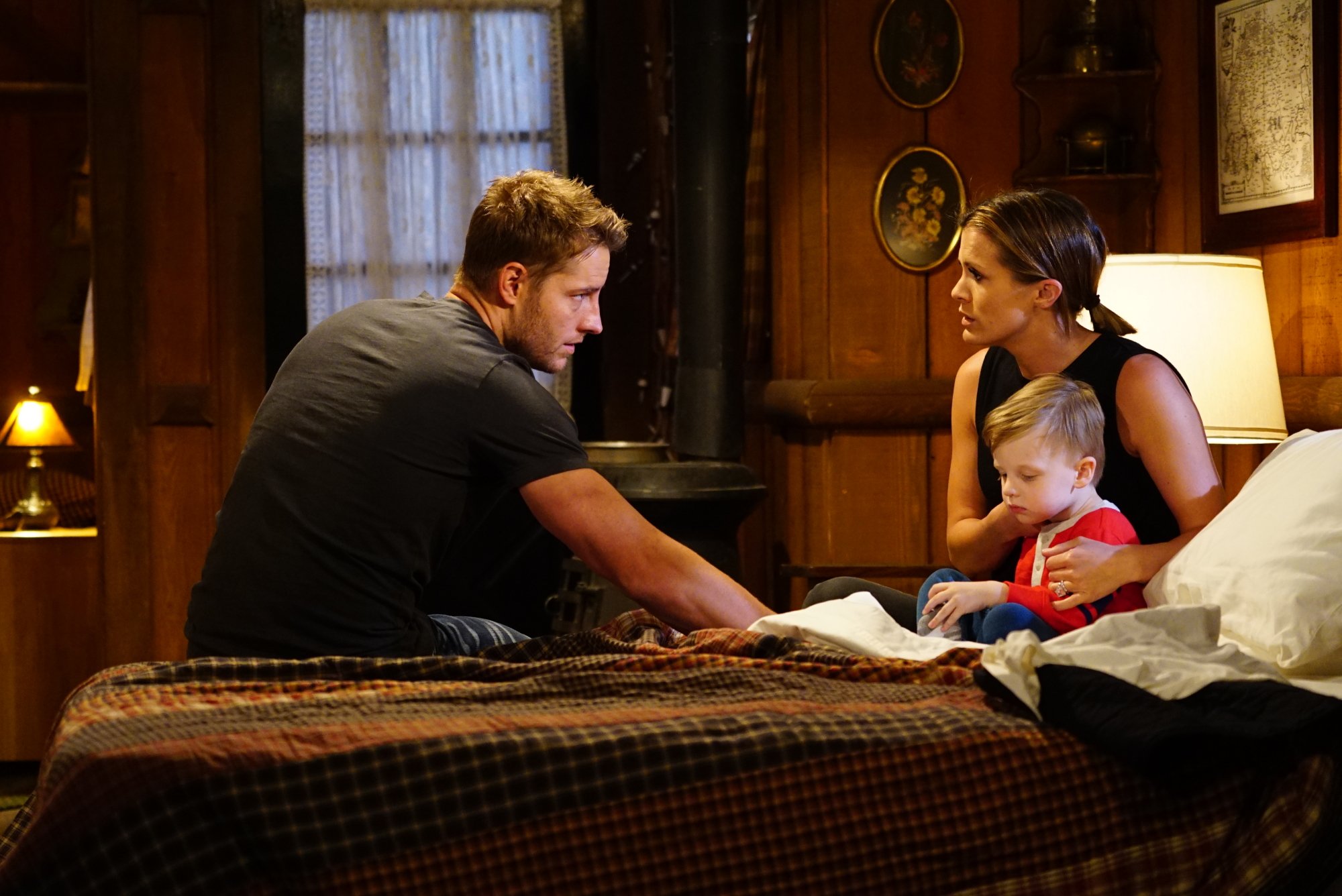 Melissa Claire Egan (Chelsea Newman) and Justin Hartley (Adam Newman) sitting on a bed with a baby
